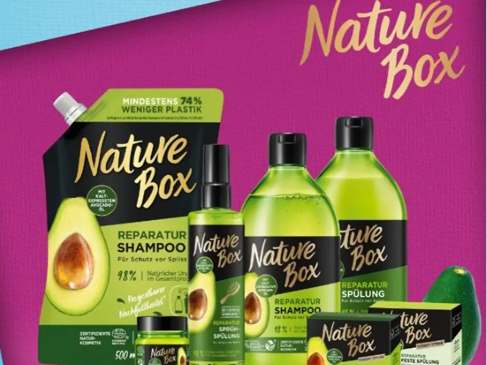 Botellas verdes de productos Nature Box sobre fondo rosa