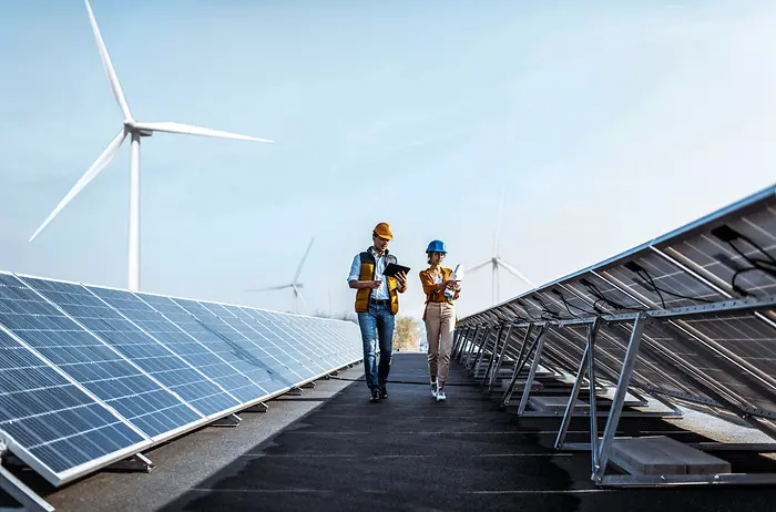 Dos hombres entre paneles solares.