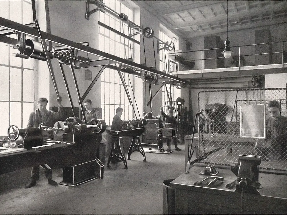 Practicantes trabajando en máquinas dentro del taller de metalurgia.